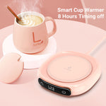 A minimalist white smart coffee mug warmer on an office desk holding a ceramic cup with steam rising